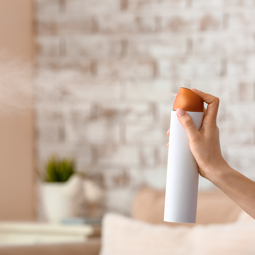 markenlose Sprayflasche, die gerade ein Produkt versprüht mit einem feinen Nebel