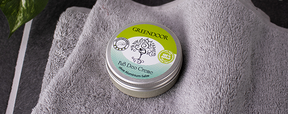 Dose GREENDOOR Fuß Deo Creme ohne Aluminium auf einem grauen Handtuch.