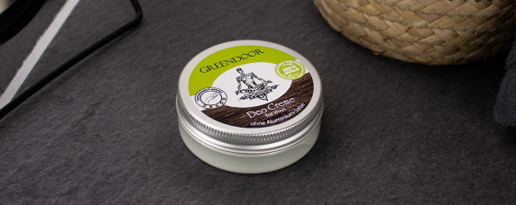 Greendoor Deo Creme im Glas ohne Aluminium auf dunklem Hintergrund, neben einem geflochtenen Korb